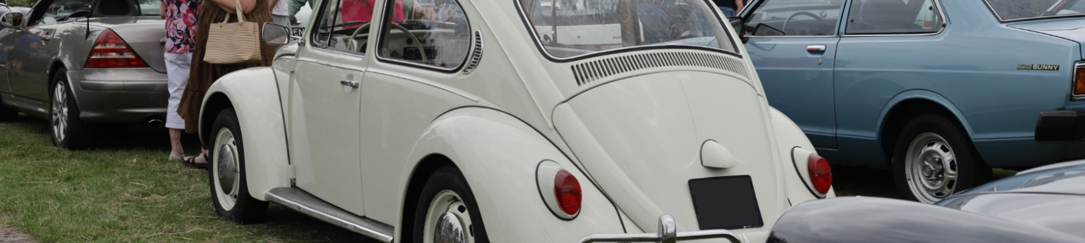 Close-up van de achterkant van een witte kever met andere auto's eromheen