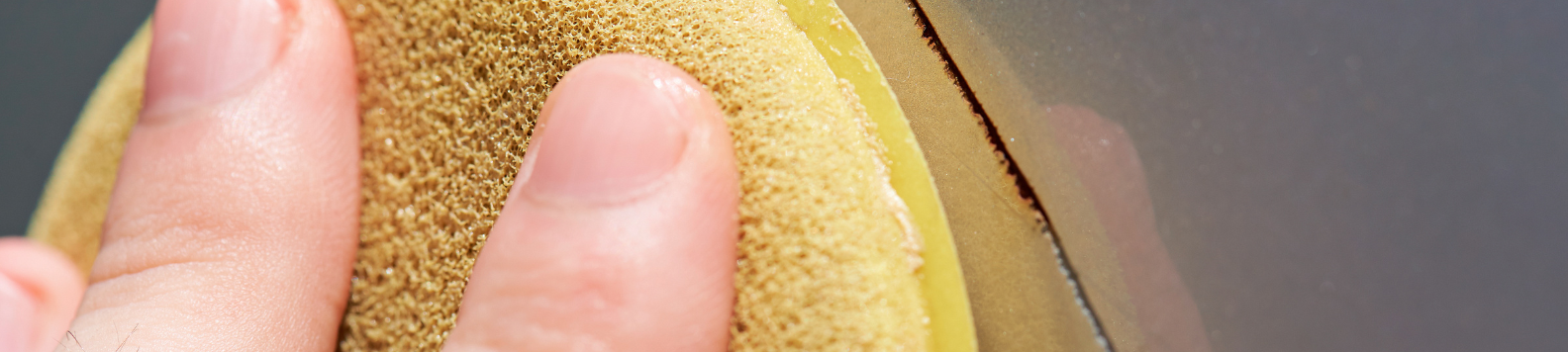 Een applicator pad wrijft over een diepe kras met roest